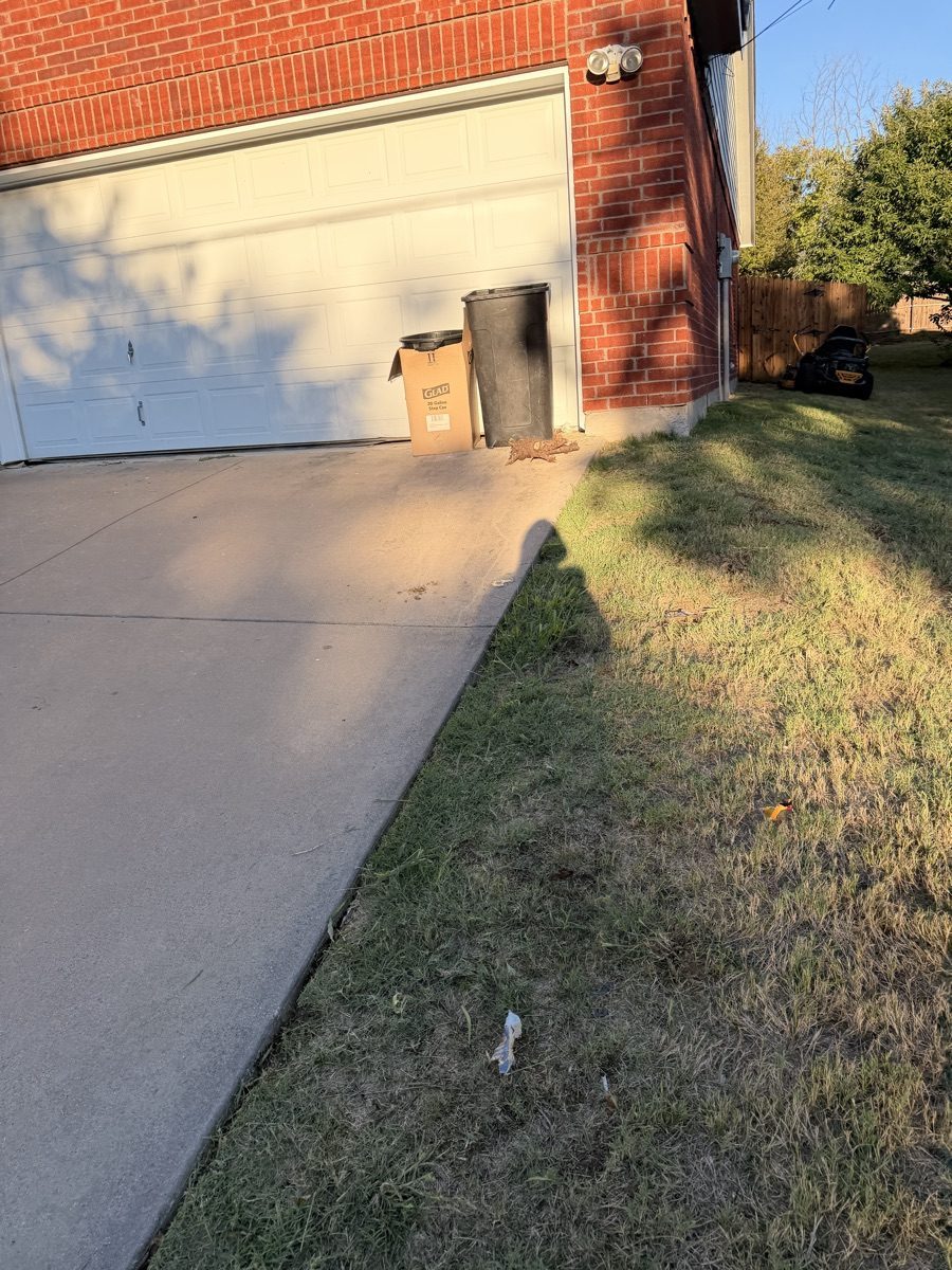 Mowed grass beside a garage and concrete driveway in Weatherford, Texas.