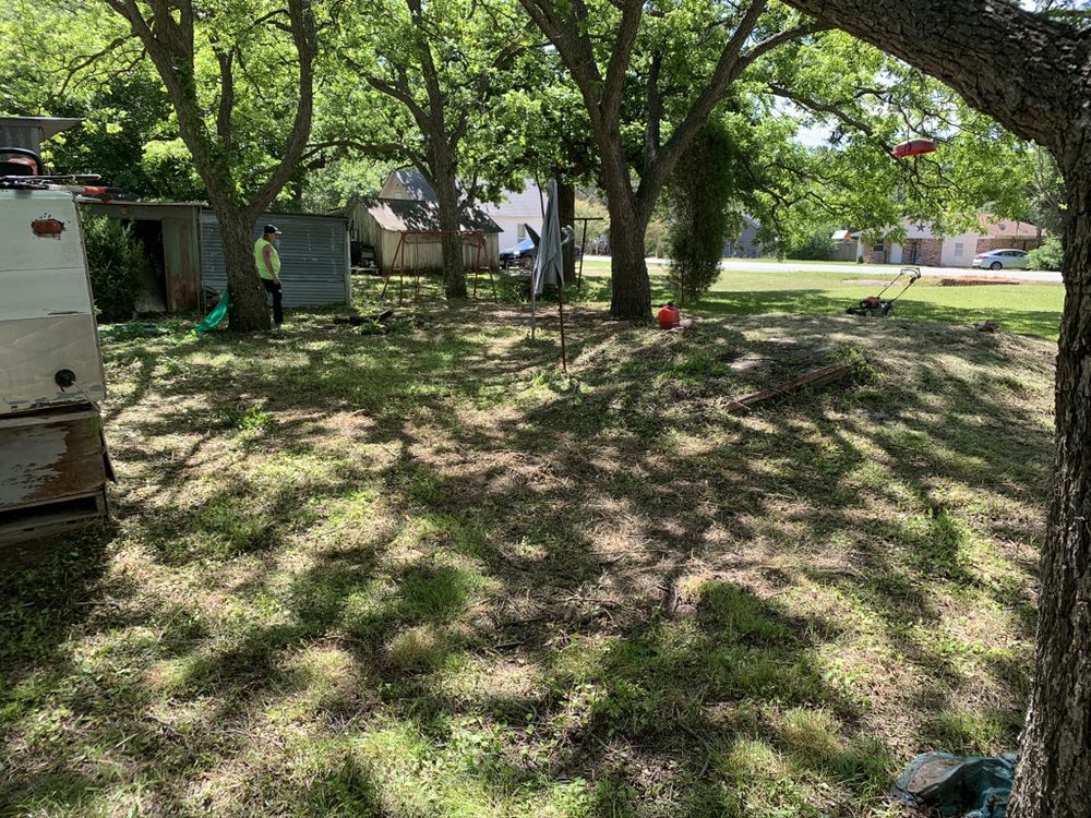 Yard Sharks crew mowing a wooded Texas property with commercial equipment